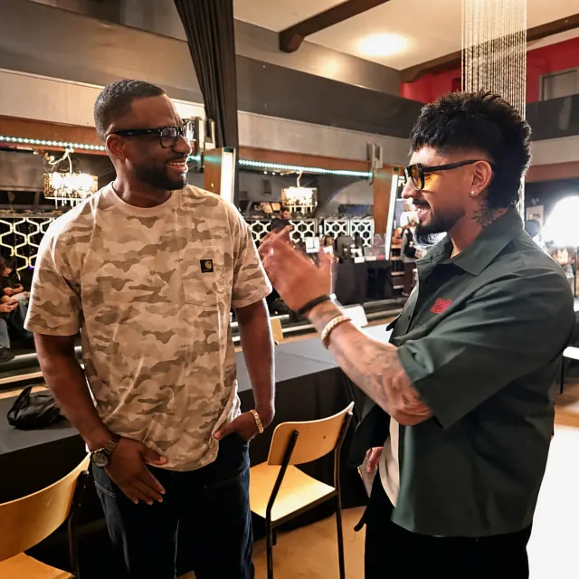 Junior in conversation with another barber inside a shop
